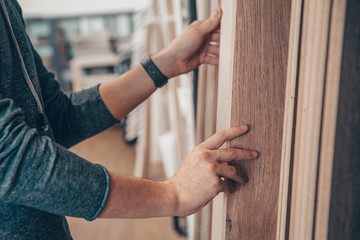 Male selects wooden floor of the sample in the specialized trade