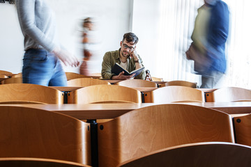 Wall Mural - Young male student taking a test in university classroom