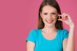 © oreans - beautiful young woman holding pill or capsule close up isolated on pink background