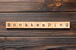 bookkeeping word written on wood block. bookkeeping text on wooden table for your desing, Top view concept
