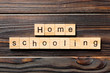 Homeschooling word written on wood block. Home schooling text on table, concept