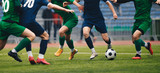 Fototapeta Sport - Soccer football player dribbling a ball and kick a ball during match in the stadium. Footballers in action on the tournament game. Adult football competition
