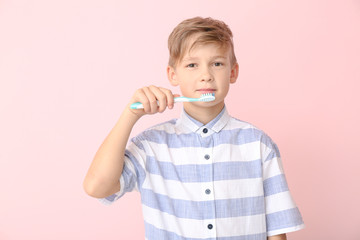 Wall Mural - Cute little boy with toothbrush on color background