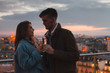 dating, young couple drinking champagne in Paris by night, cheers on rooftop terrace of luxury restaurant