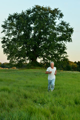 Poster - Portrait of happy man running in summer field