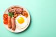 Delicious breakfast or lunch with fried eggs on mint background, top view
