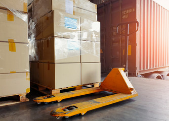 Wall Mural - Hand pallet truck and stack of package boxes on pallet, truck container docking load shipment goods at warehouse, road freight industry delivery transport.