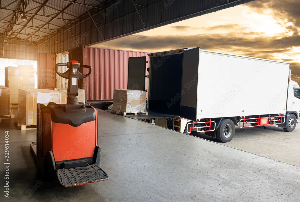 Truck container docking load shipment goods at warehouse, forklift   pallet jack with stack package boxes on pallet, road freight industry delivery logistics and transport. - obrazy, fototapety, plakaty 