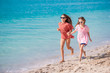 © travnikovstudio - Little happy funny girls have a lot of fun at tropical beach playing together.