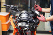 An auto mechanic uses a multimeter voltmeter to check the voltage level in a motorcycle , selective focus