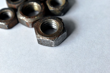 Wall Mural - Rusty old battered iron nuts on a white background