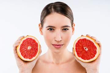 Wall Mural - Close up beauty woman with perfect skin nude make up holding grapefruit isolated on white background. Healthcare cosmetic procedures concept