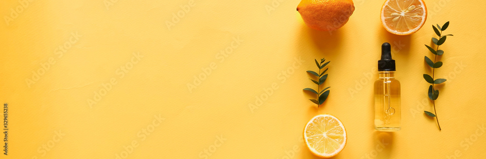 bright flatlay composition with oil, citrus and eucalyptus. on yellow background. Concept beauty natural vitamin cosmetic product, skin care, copyspace, top view, banner - obrazy, fototapety, plakaty 