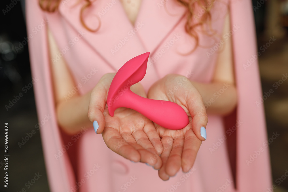 Photo Stock Woman hands hold sex toys. Erotic pleasure toy on a woman hand. Sex gadget and masturbation device for adult. A pink rubber anal plug in a female hand. Sex shop Photo Stock Woman hands hold sex toys. Erotic pleasure toy on a woman hand. Sex gadget and masturbation device for adult. A pink rubber anal plug in a female hand. Sex shop