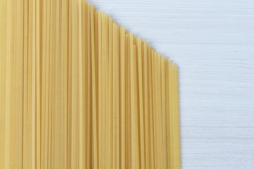 Italian long pasta, on white textured wooden background