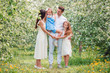 © travnikovstudio - Adorable family in blooming cherry garden on beautiful spring day