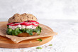 Spring sandwich with cottage cheese, radish, chives and lamb's lettuce on a light background