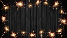 Silvester Festive Background - Frame Made Of Sparklers On Rustic Wooden Black Texture, With Space For Text