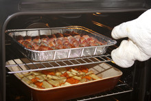 An Oven Full Of Sausages With Bacon And Roasting Vegetables