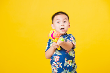 little children boy so happy in Songkran festival day holding water gun