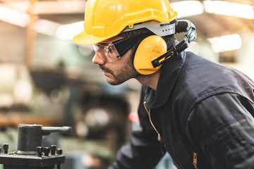 Wall Mural - Industrial Engineers in Hard Hats.Work at the Heavy Industry Manufacturing Factory.industrial worker indoors in factory. man working in an industrial factory.