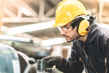 Wall Mural - Industrial Engineers in Hard Hats.Work at the Heavy Industry Manufacturing Factory.industrial worker indoors in factory. man working in an industrial factory.