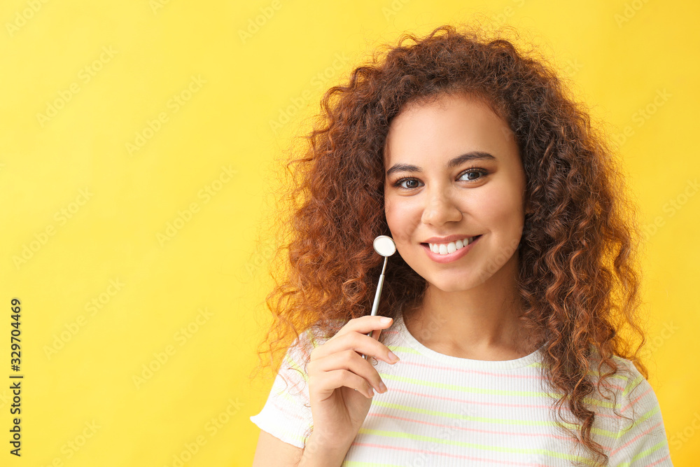 Young woman with dentist mirror on color background