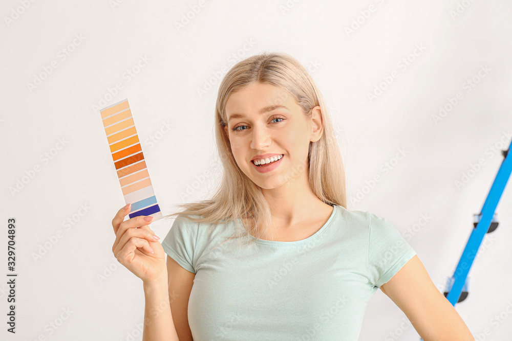 Young woman with color swatches on white background