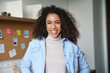 © insta_photos - Smiling confident millennial african american woman look at camera standing at home office workspace with sticky notes. Happy mixed race female student professional designer freelancer portrait.