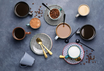 Composition with cups of different coffee on grunge background