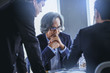 © Panumas - Talking about serious business. Thoughtful business peoples holding hands clasped and looking to business partner while sitting at his working place.