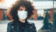 Curly Haired Caucasian Lady Posing Outside While Wearing A Protective Mask