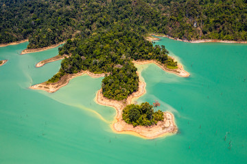 Wall Mural - Aerial view looking downwards onto tiny islands and fingers of tropical rainforest covered land in a huge lake