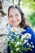 © DariaTrofimova - elderly woman  with flowers against  nature.