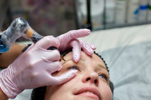 Permanent Makeup, Eyebrow Tattooing. The Master Makes Permanent Makeup Using Machine Tattoos