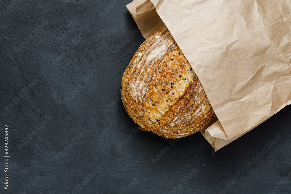 ภาพถ่าย Stock Fresh baked rustic bread loaf in paper bag. Artisan bread ...