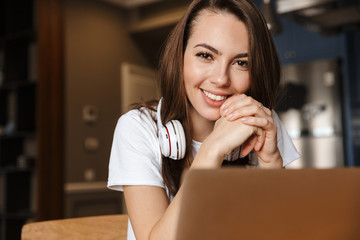 Canvas Print - Image of joyful beautiful woman smiling and working with laptop