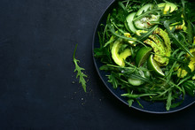 Green Vegetable Salad With Arugula, Cucumber And Avocado. Top View With Copy Space.