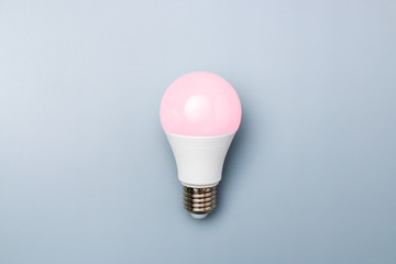 Wall Mural - led bulb with pink light against a grey background with copy space. energy efficiency concept