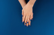 © fotofabrika - Female hands with manicure of classic blue color on blue background. Close up