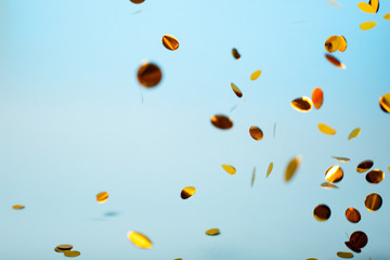 Orange and yellow falling confetti on blue background