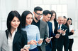 © yurolaitsalbert - group of business people with smartphones standing in a row