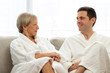 © karelnoppe - Middle aged couple in bathrobes at home.