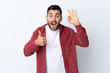 © luismolinero - Young handsome man with beard wearing a corduroy jacket over isolated white background showing ok sign and thumb up gesture