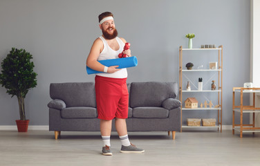 Wall Mural - Funny fat man with dumbbells doing exercises in the room.