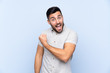 © luismolinero - Young handsome man with beard over isolated blue background celebrating a victory