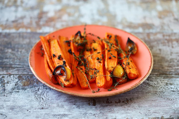 Wall Mural - Selective focus. A plate with baked carrots. Macro. Baked carrots in strips with herbs and spices. Vegan diet. Vegan lunch recipe idea.