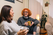 © cherryandbees - mid age woman friends having coffee and talking at home