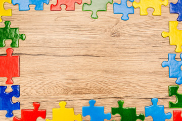 Sticker - Top view of bright multicolored pieces of puzzle on wooden background, autism concept