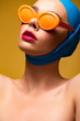 © LIGHTFIELD STUDIOS - attractive fashionable girl in scarf and trendy sunglasses, isolated on yellow